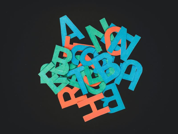 Litery alfabetu w różnych kolorach porozrzucane na blacie