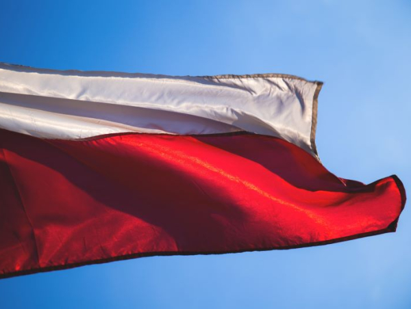 Flaga Polski powiewająca na tle nieba