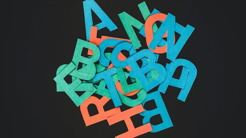 Litery alfabetu w różnych kolorach porozrzucane na blacie